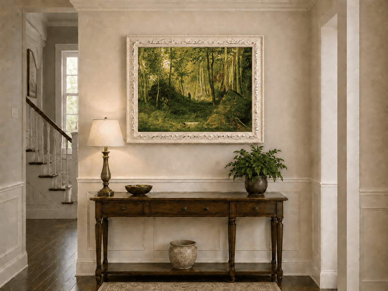 Framed hand-painted forest glade oil painting with a figure, rocks and filtered sunlight displayed above an entryway console table.