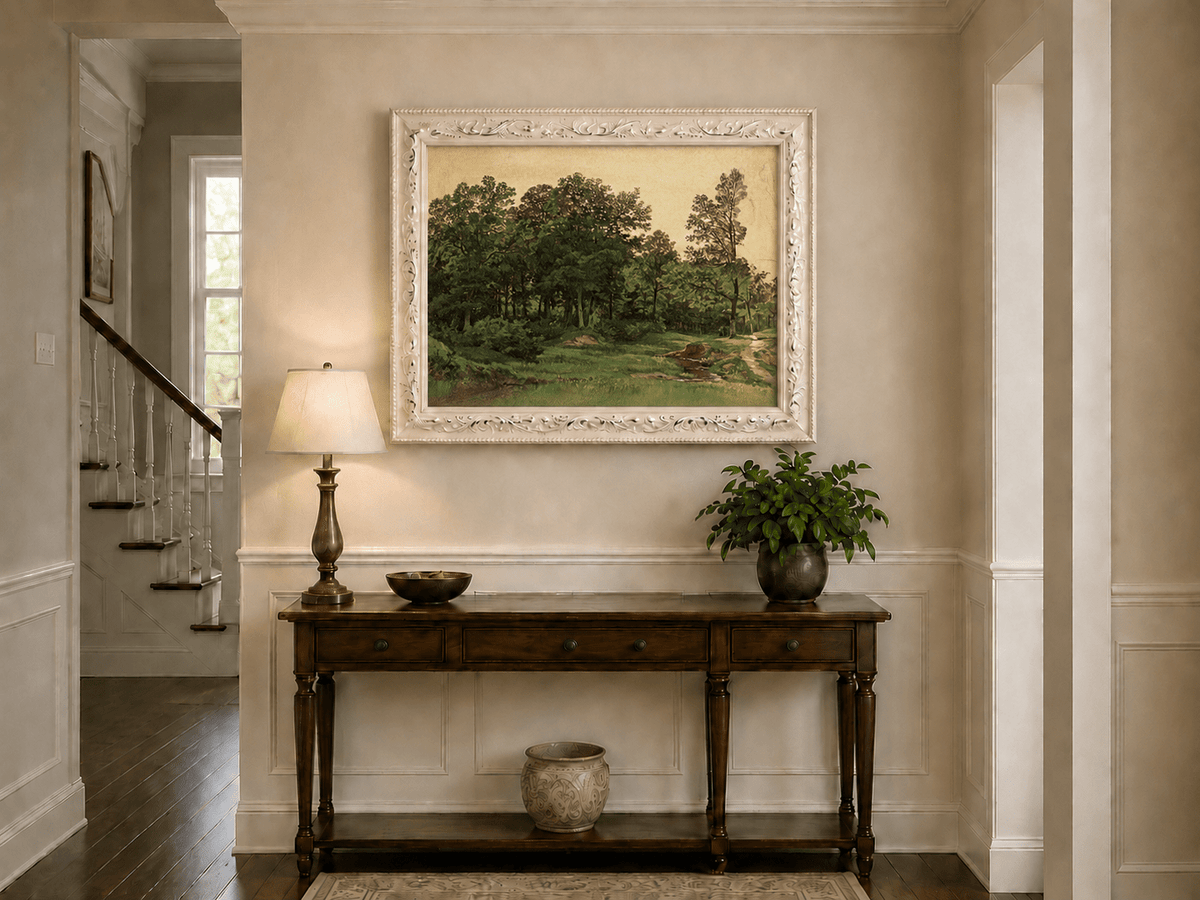 Framed hand-painted forest glade oil painting with a winding stream displayed above an entryway console table.