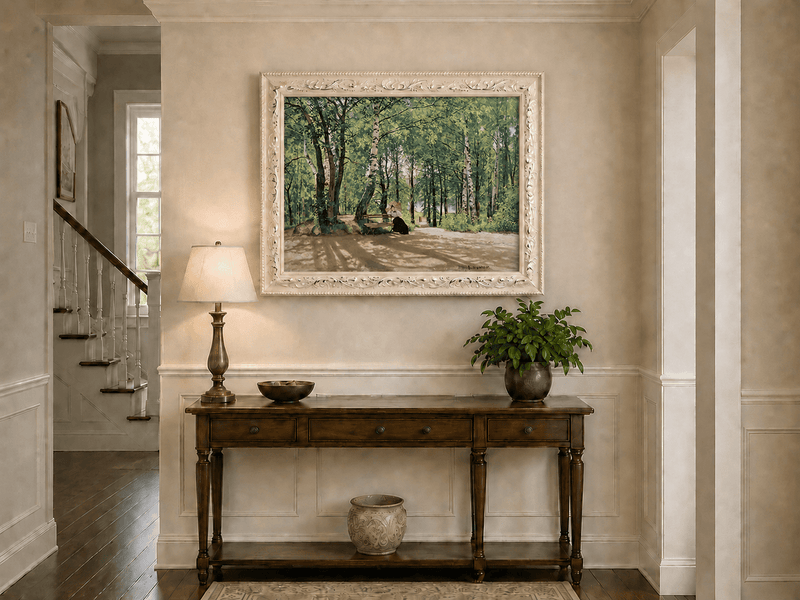 Framed hand-painted forest path oil painting with a figure resting near a bench displayed above an entryway console table.