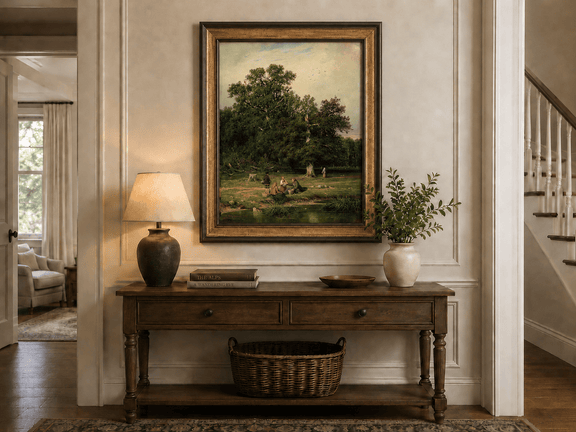 Framed hand-painted forest stream oil painting with figures beneath a large tree displayed above an entryway console table.