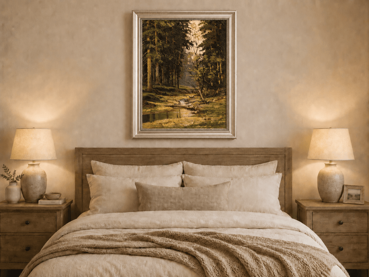 Framed hand-painted forest stream oil painting with tall trees and warm filtered light displayed above a wooden bed in a neutral bedroom.