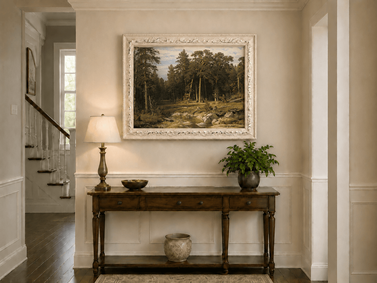 Framed hand-painted forest stream oil painting with tall pine trees and rocky water displayed above an entryway console table.