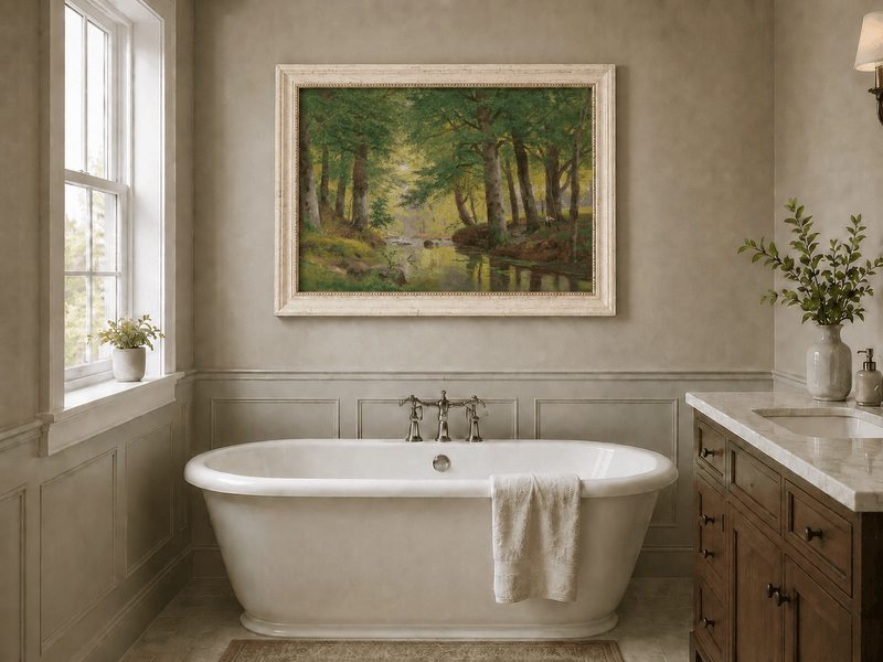 Framed hand-painted forest stream oil painting with tall trees and bright reflections displayed above a freestanding bathtub.