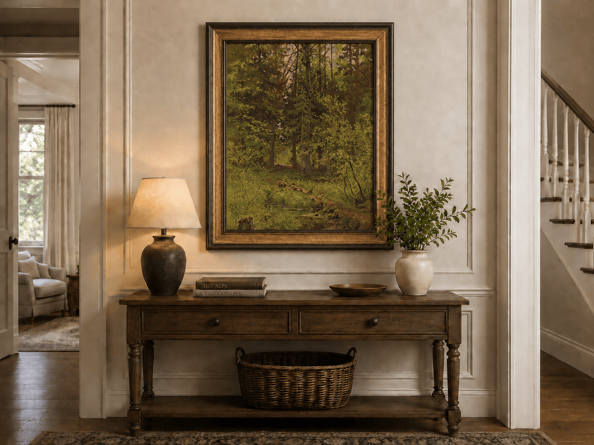 Framed hand-painted woodland stream oil painting with dense trees and shadowed water displayed above an entryway console table.