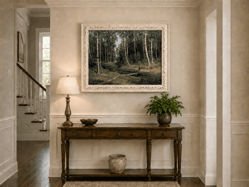 Framed hand-painted forest stream oil painting with figures among the trees displayed above an entryway console table.