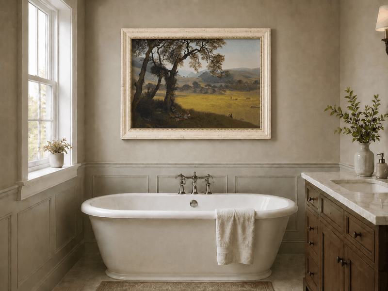 Framed hand-painted golden meadow oil painting with a picnic scene beneath a broad tree displayed above a freestanding bathtub.