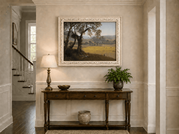 Framed hand-painted golden meadow oil painting with a picnic scene beneath a broad tree displayed above an entryway console table.