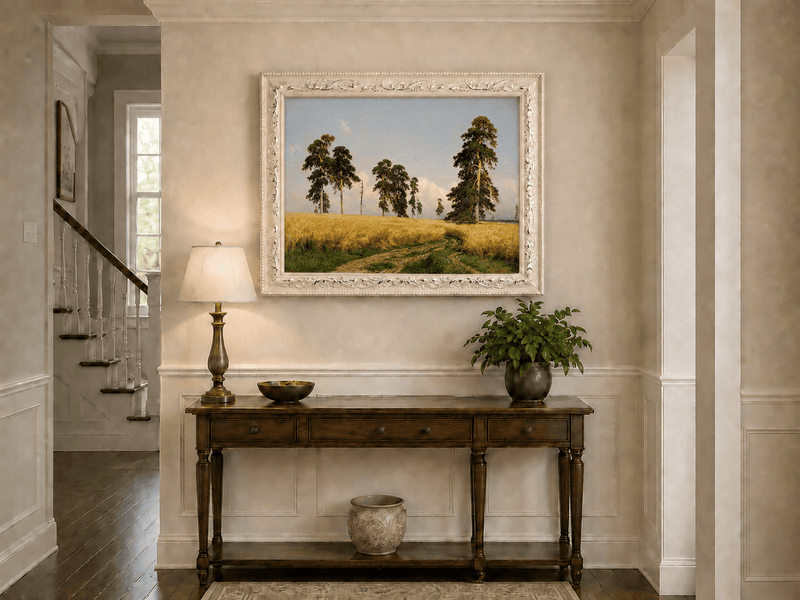 Framed hand-painted golden wheat field oil painting with pine trees and a country path displayed above an entryway console table.