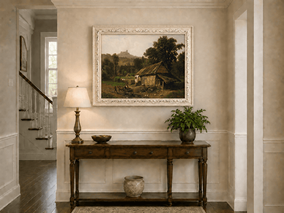 Framed hand-painted rural cottage oil painting with poultry and a distant castle displayed above an entryway console table.