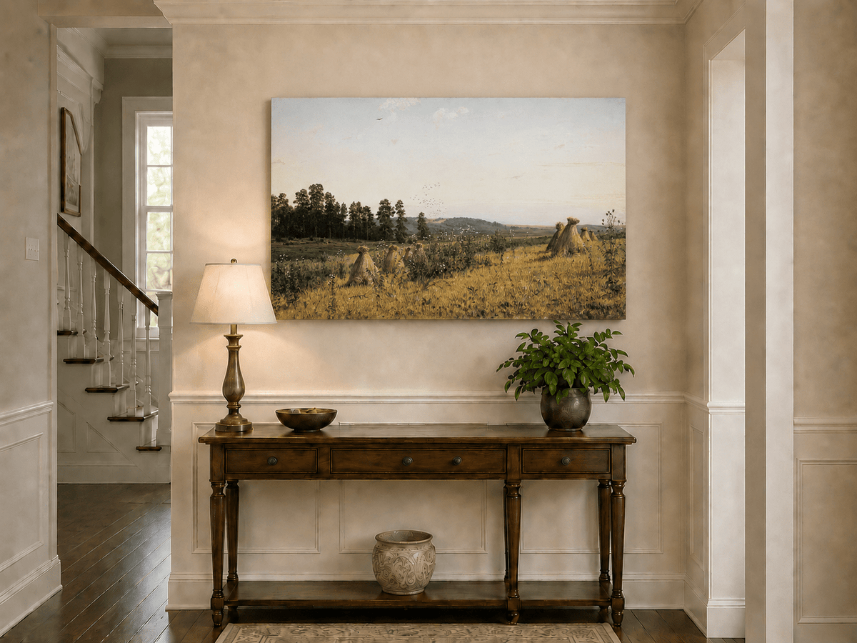 Unframed hand-painted harvest field oil painting with haystacks and distant farm workers displayed above an entryway console table.