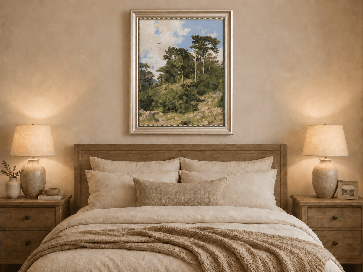 Framed hand-painted hillside oil painting with pine trees, rocks and open sky displayed above a wooden bed in a neutral bedroom.