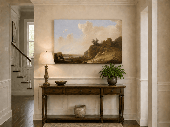 Unframed hand-painted landscape oil painting with hilltop ruins, figures and a winding road displayed above an entryway console table.