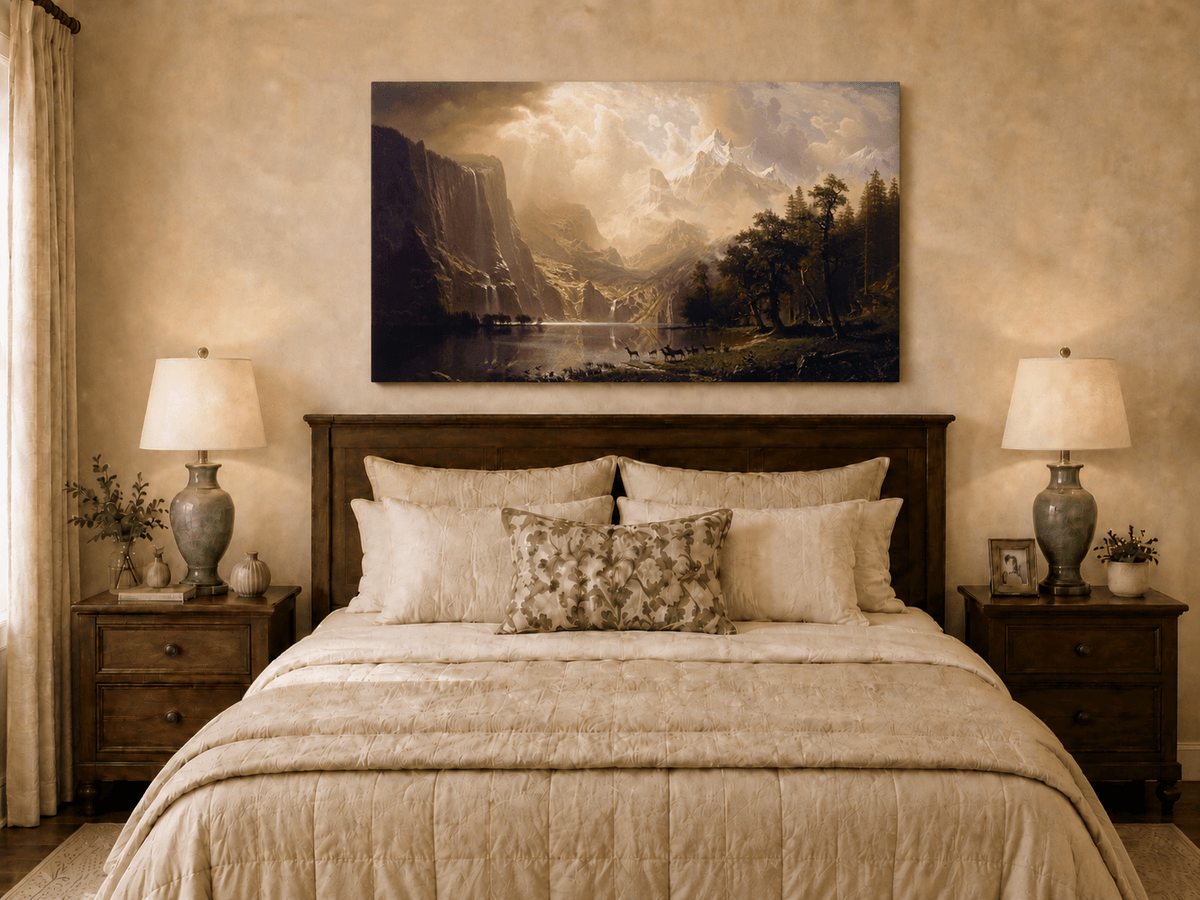 Unframed hand-painted mountain stream oil painting with dramatic holy light breaking through clouds displayed above a wooden bed in a neutral bedroom.