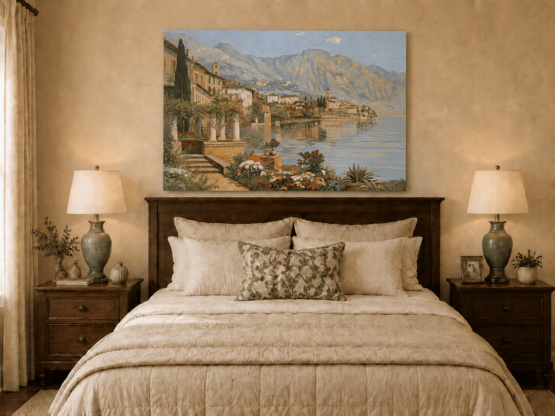 Unframed hand-painted lakeside village oil painting with flowers and mountains displayed above a wooden bed in a neutral bedroom.