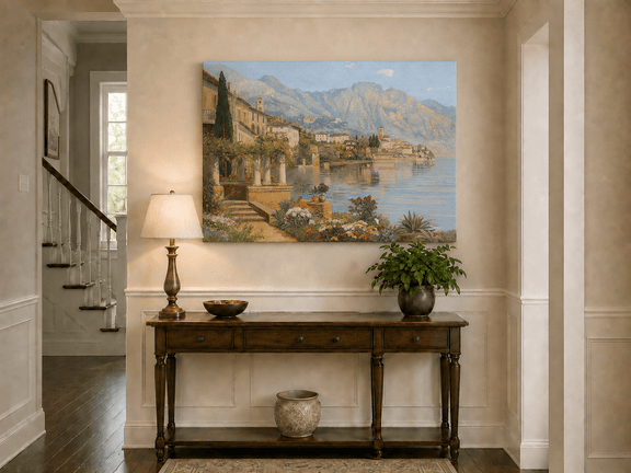 Unframed hand-painted lakeside village oil painting with flowers and mountains displayed above an entryway console table.