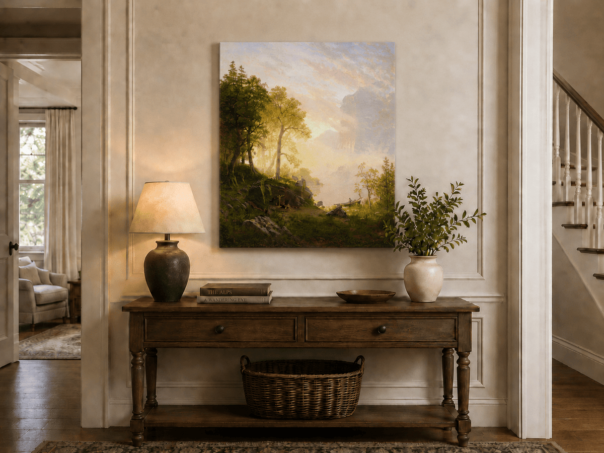 Unframed hand-painted lakeside woodland oil painting with a camp, angler and misty peaks displayed above an entryway console table.