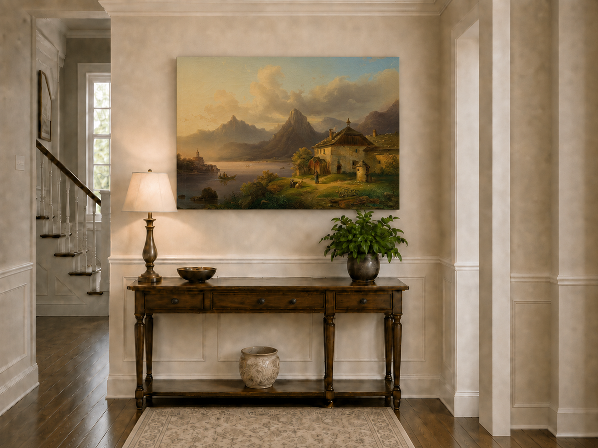 Hand-painted alpine lake cottage with sunset mountain landscape oil painting displayed above a console table in a hallway interior.