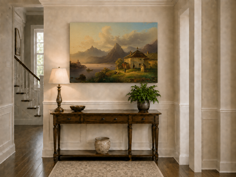 Hand-painted alpine lake cottage with sunset mountain landscape oil painting displayed above a console table in a hallway interior.