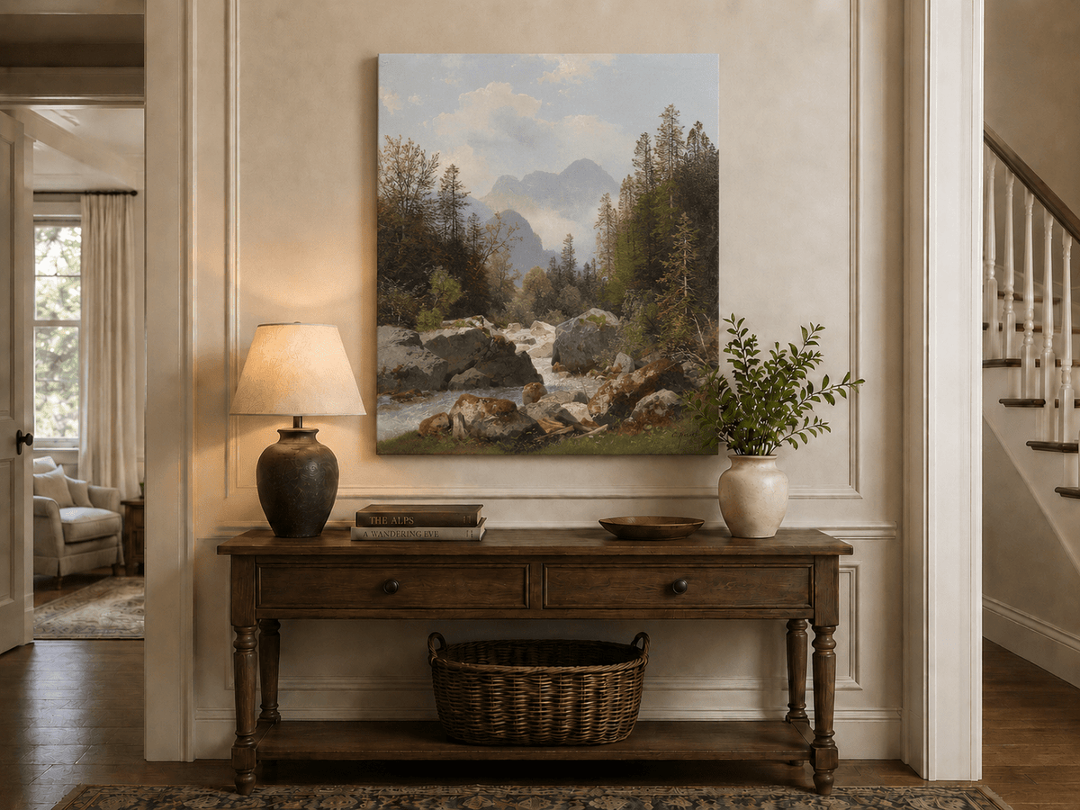 Hand-painted alpine stream with pines and boulders landscape oil painting displayed above a console table in a hallway interior.