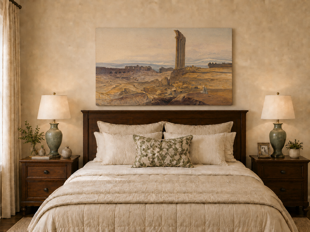 Hand-painted ancient ruins with a column in the desert landscape oil painting displayed above a bed in a bedroom interior.