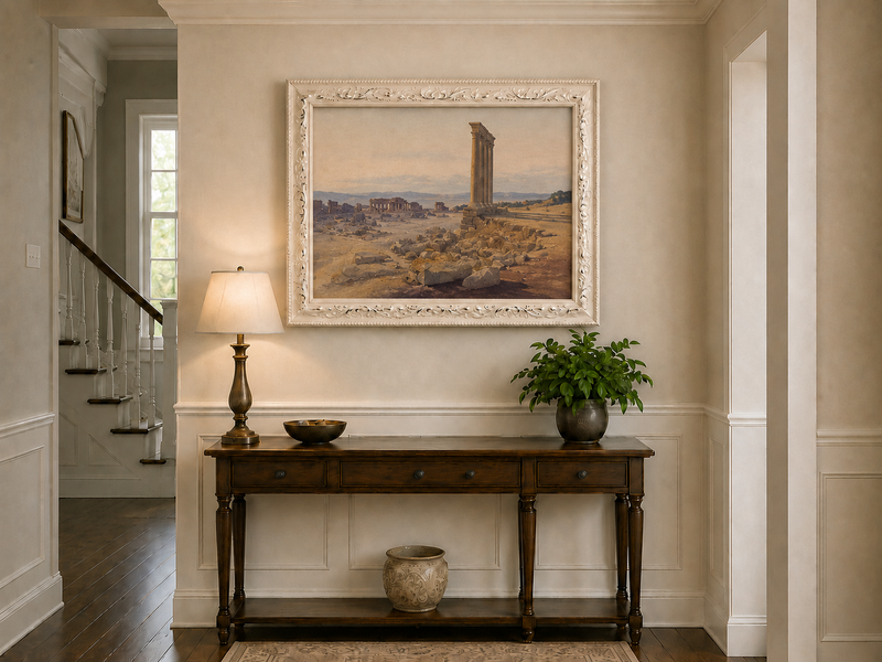 Hand-painted ancient ruins with a column in the desert landscape oil painting displayed above a console table in a hallway interior.