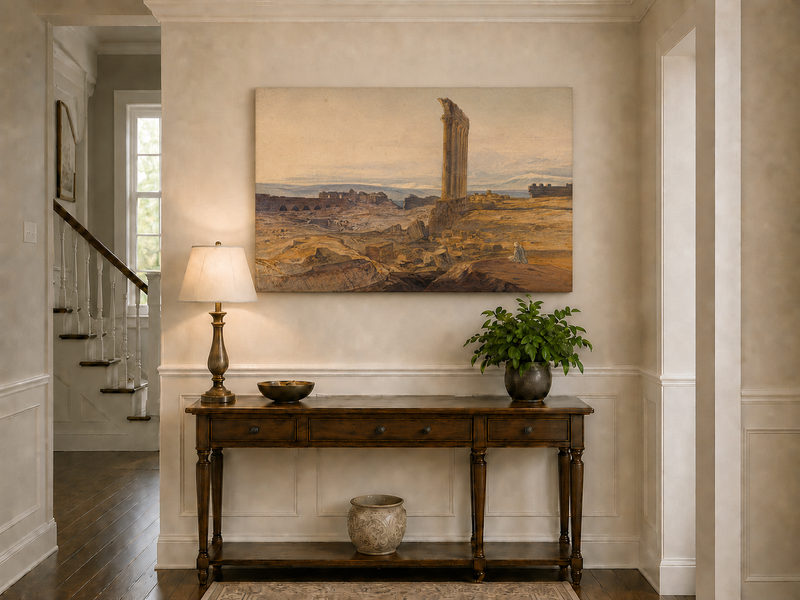 Hand-painted ancient ruins with a column in the desert landscape oil painting displayed above a console table in a hallway interior.