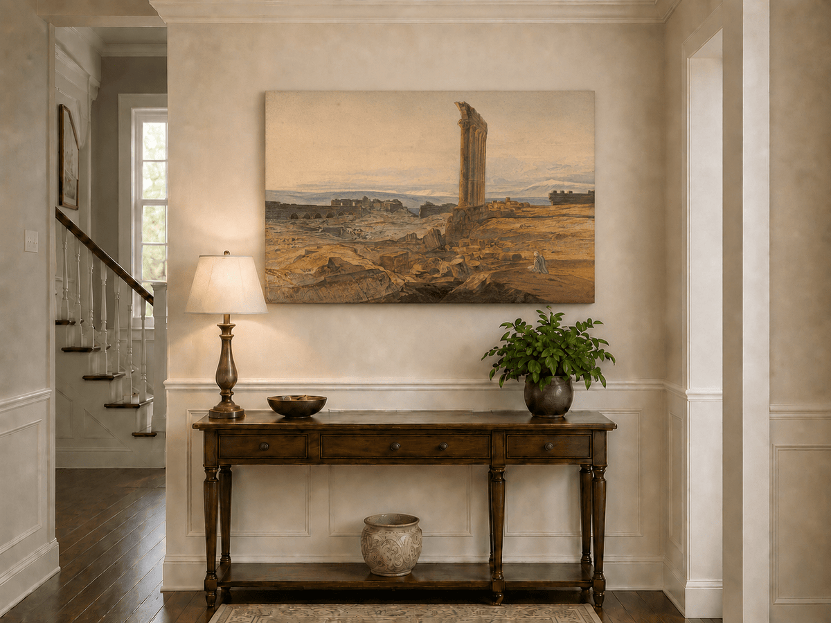 Hand-painted ancient ruins with a column in the desert landscape oil painting displayed above a console table in a hallway interior.