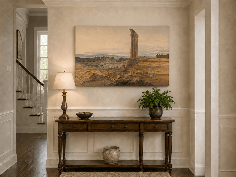 Hand-painted ancient ruins with a column in the desert landscape oil painting displayed above a console table in a hallway interior.