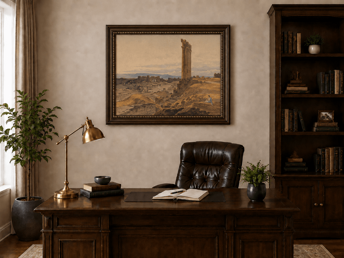 Hand-painted ancient ruins with a column in the desert landscape oil painting displayed above a desk in a home office interior.