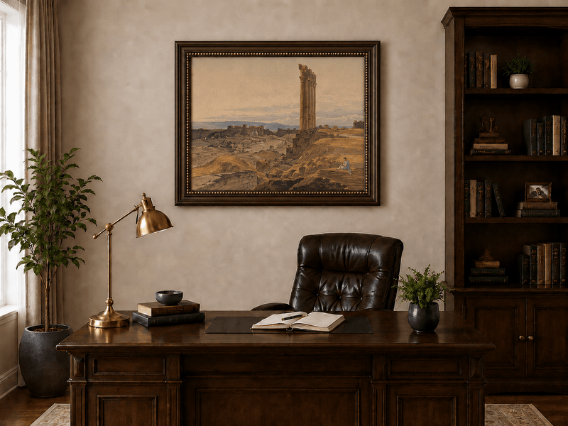 Hand-painted ancient ruins with a column in the desert landscape oil painting displayed above a desk in a home office interior.