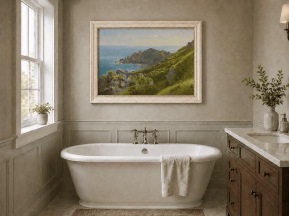 Framed hand-painted coastal landscape oil painting with green hills, rocky headland and ocean displayed above a freestanding bathtub.