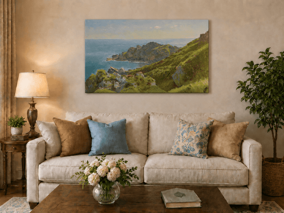 Unframed hand-painted coastal landscape oil painting with green hills, rocky headland and ocean displayed above a neutral living room sofa.