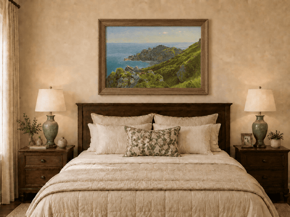 Framed hand-painted coastal landscape oil painting with green hills, rocky headland and ocean displayed above a wooden bed in a neutral bedroom.