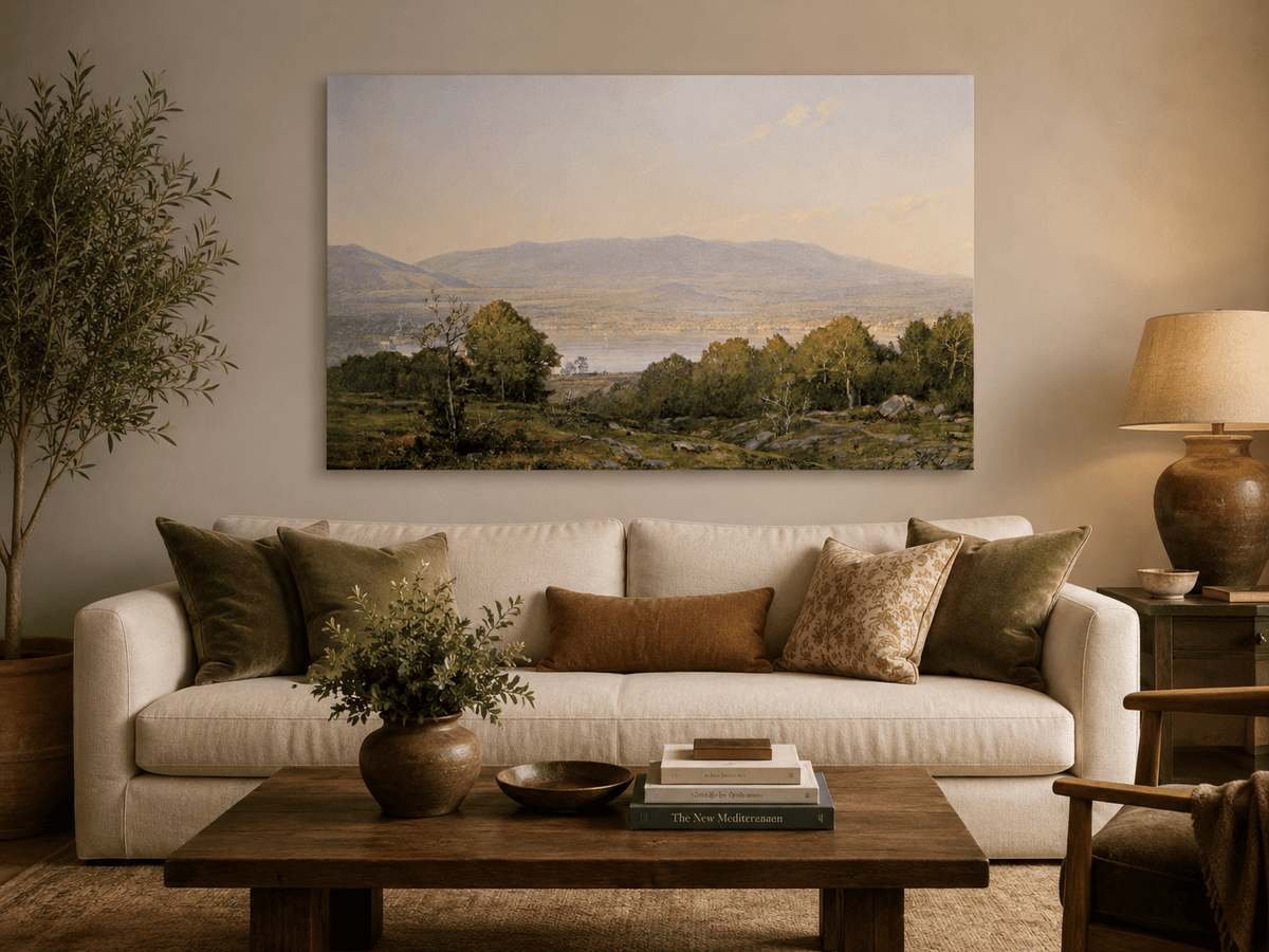 Unframed hand-painted dusk lake oil painting with distant mountains and wooded hills displayed above a neutral living room sofa.