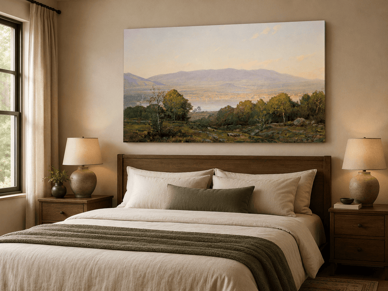 Unframed hand-painted dusk lake oil painting with distant mountains and wooded hills displayed above a wooden bed in a neutral bedroom.