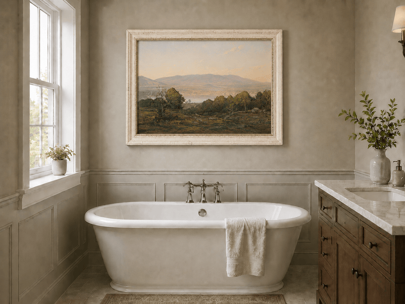 Framed hand-painted dusk lake oil painting with distant mountains and wooded hills displayed above a freestanding bathtub.