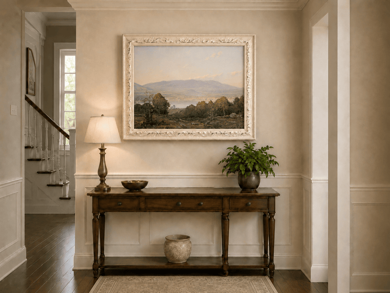 Framed hand-painted dusk lake oil painting with distant mountains and wooded hills displayed above an entryway console table.
