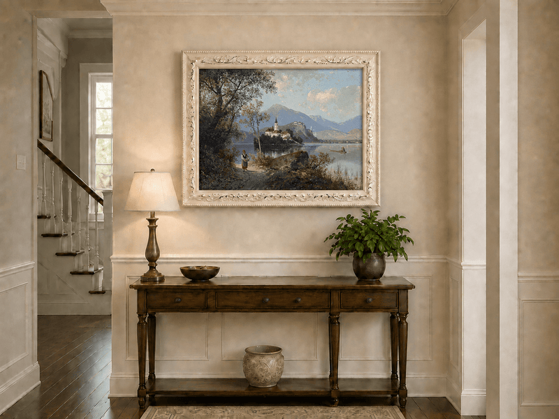 Hand-painted European lakeside village landscape oil painting displayed above a console table in a hallway interior.