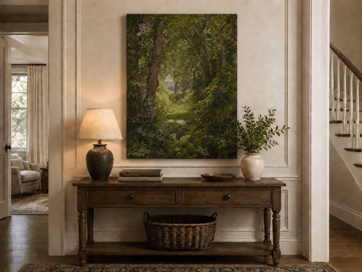 Unframed hand-painted woodland oil painting with a green path leading to a small pond displayed above an entryway console table.
