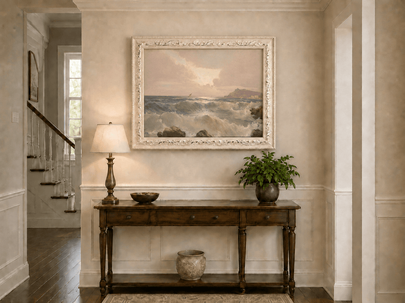 Landscape oil painting of coastal waves at dusk displayed above a console table in a hallway interior.