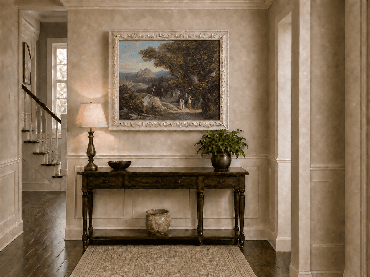Hand-painted path with figures, cross and distant mountain peaks landscape oil painting displayed above a console table in a hallway interior.
