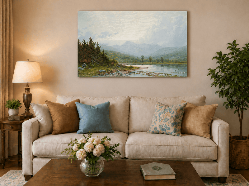 Unframed hand-painted lake shore oil painting with pine shade, still water and mountain peaks displayed above a neutral living room sofa.