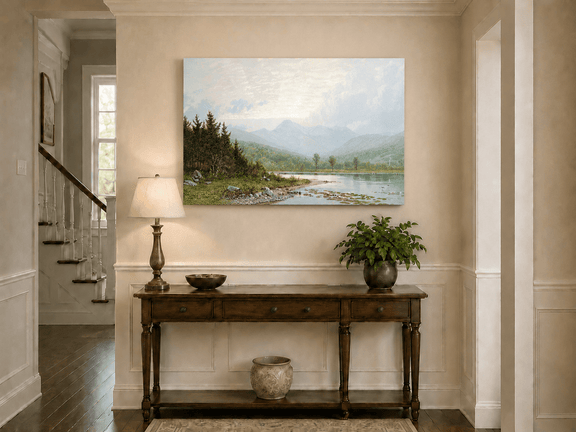 Unframed hand-painted lake shore oil painting with pine shade, still water and mountain peaks displayed above an entryway console table.