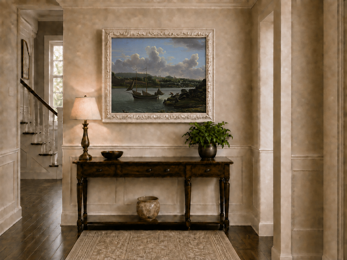 Hand-painted riverside sailboat with figures, dogs and distant hills landscape oil painting displayed above a console table in a hallway interior.
