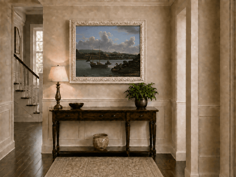 Hand-painted riverside sailboat with figures, dogs and distant hills landscape oil painting displayed above a console table in a hallway interior.