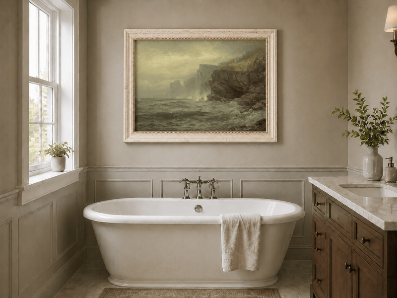 Framed hand-painted rocky seaside oil painting with churning waves and misty cliffs displayed above a freestanding bathtub.