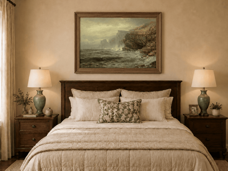 Framed hand-painted rocky seaside oil painting with churning waves and misty cliffs displayed above a wooden bed in a neutral bedroom.