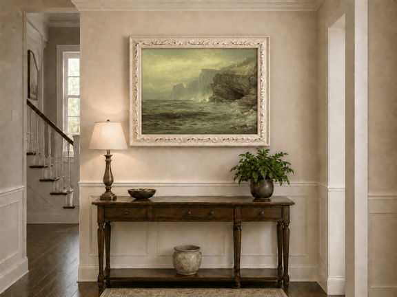 Framed hand-painted rocky seaside oil painting with churning waves and misty cliffs displayed above an entryway console table.