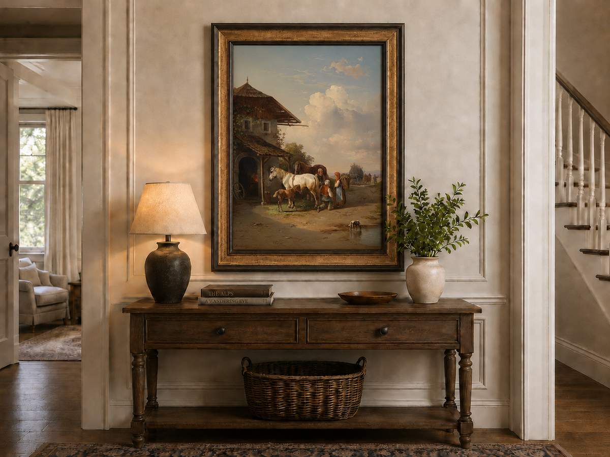Hand-painted rural cottage, horses and village life landscape oil painting displayed above a console table in a hallway interior.