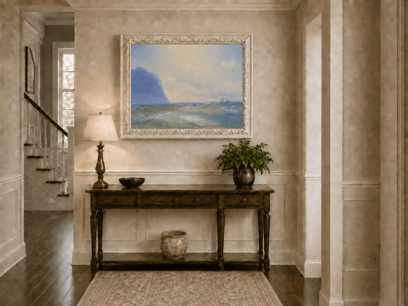 Hand-painted sailing beyond the blue cliff seascape oil painting displayed above a console table in a hallway interior.